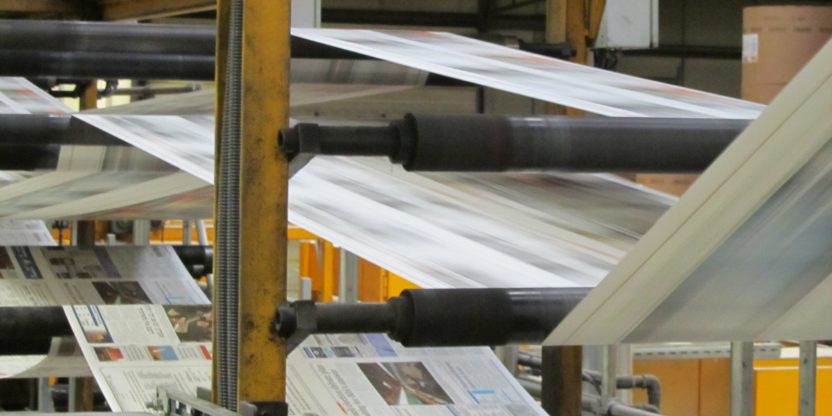 A photo of a newspaper printing press in operation