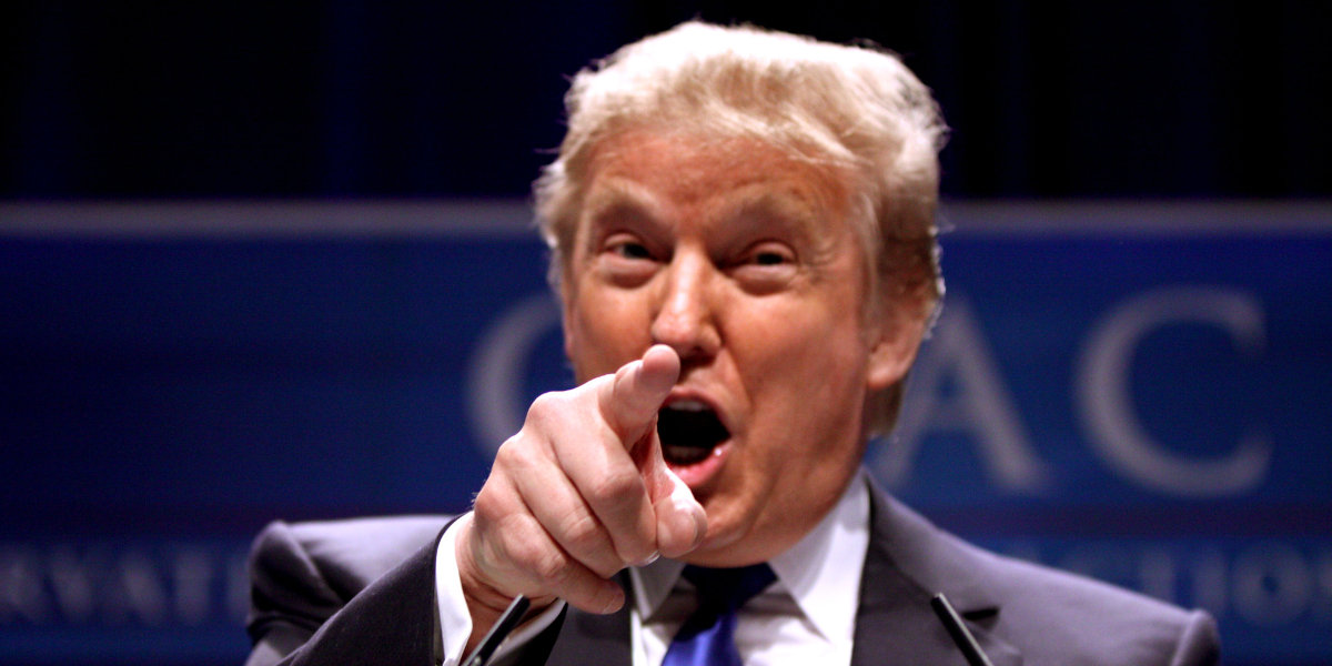 Donald Trump in close up, pointing directly into the camera, mouth open wide