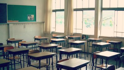 photo of empty school desks and large window in classroom