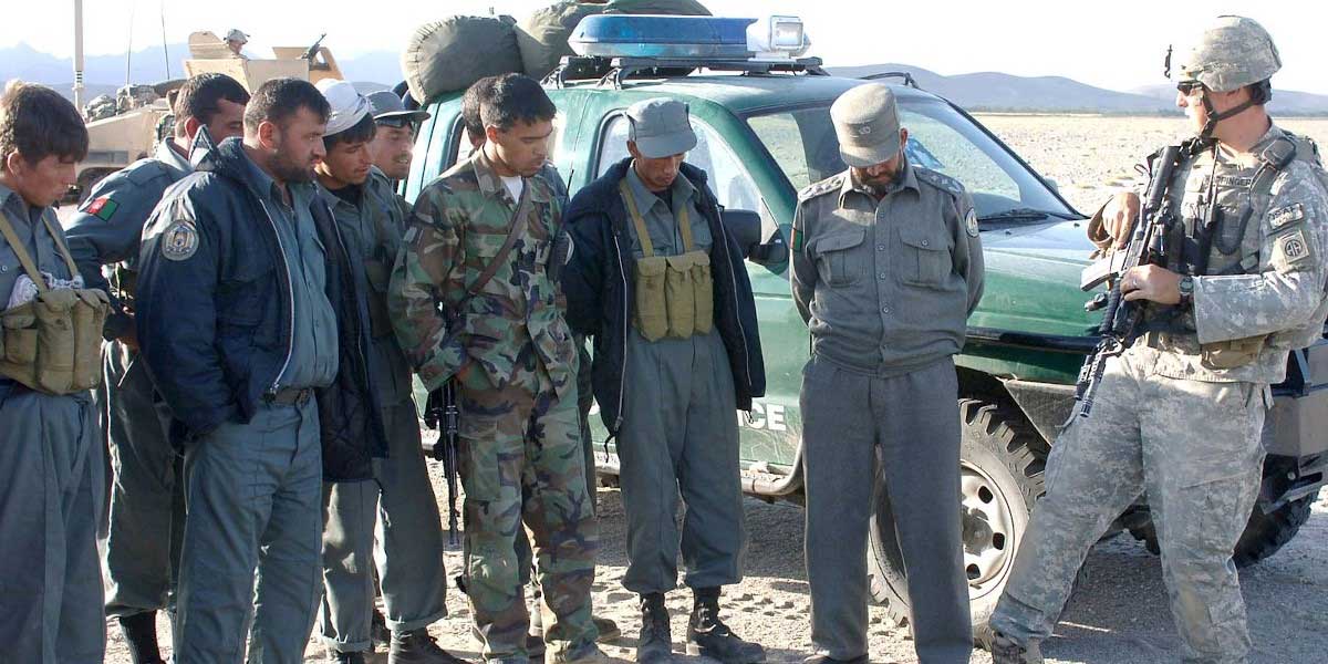 Group of Afghan soldiers with one US soldier explaining something to them