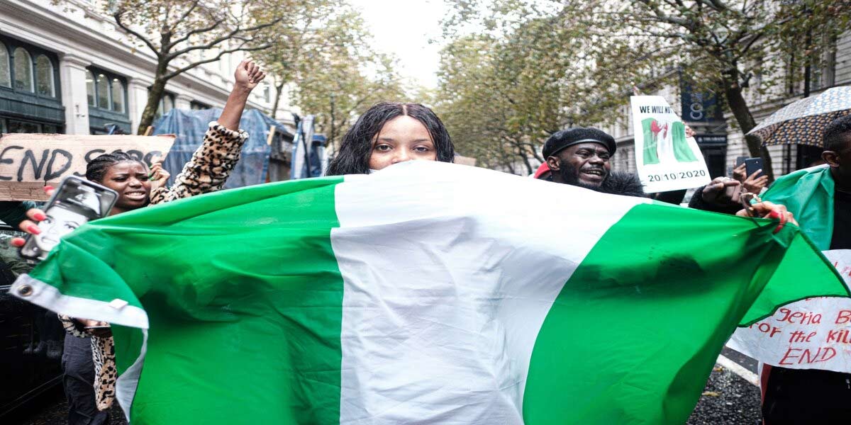 Protesters behind a Nigerian flag at a demonstration