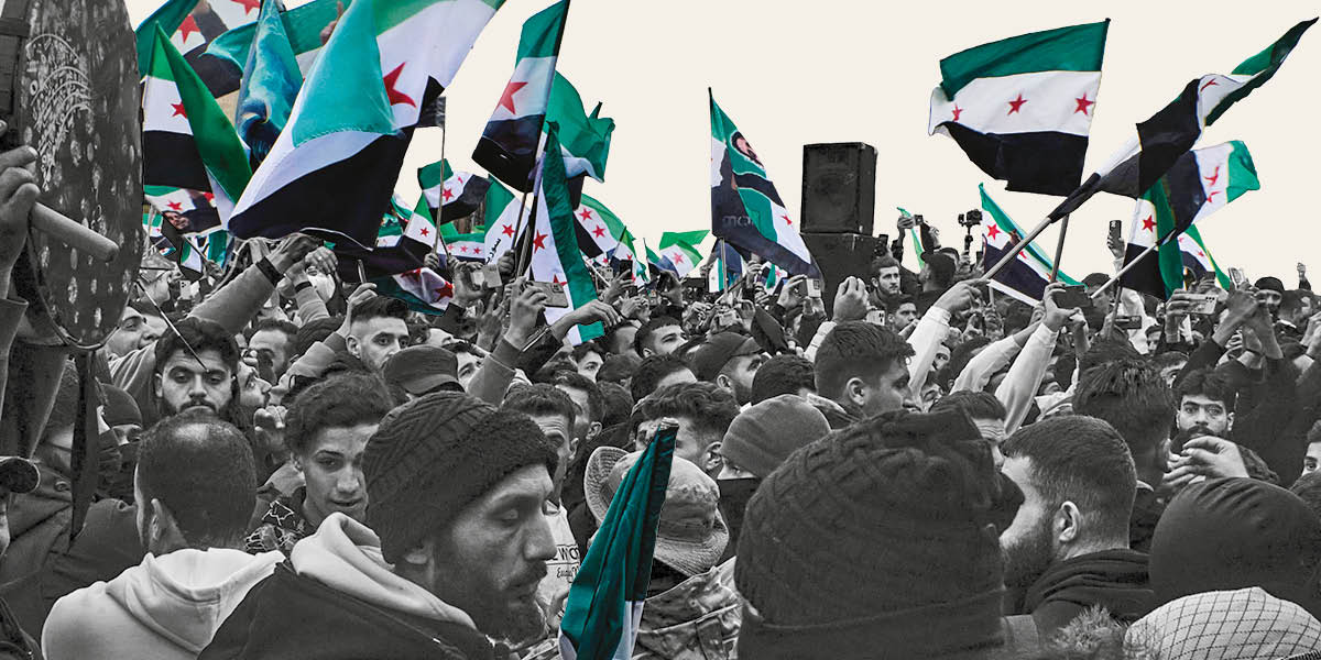 A huge crowd of people waving Syrian flags